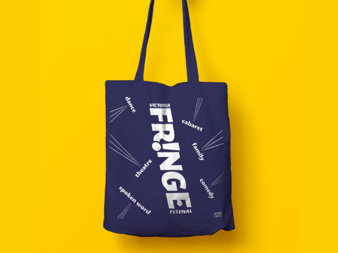 Royal blue tote bag with white lettering that says Victoria Fringe Festival, on a bright yellow background.