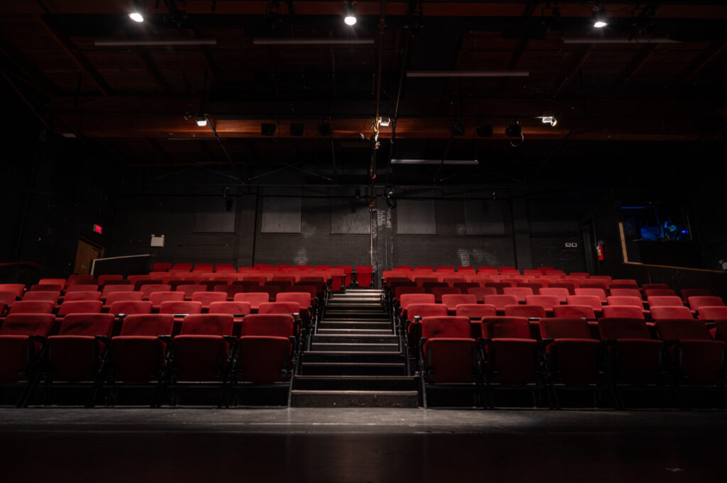 A photo of the metro studio audience seating. Red chairs and an aisle down the centre. 