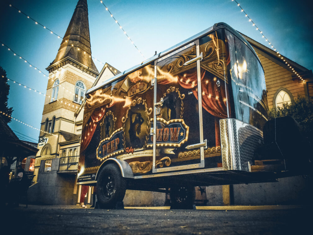 Image: A circus caravan with sexy carnival graphics parked at picturesque Fernwood Square CREDIT : Holly Shirt, Photography