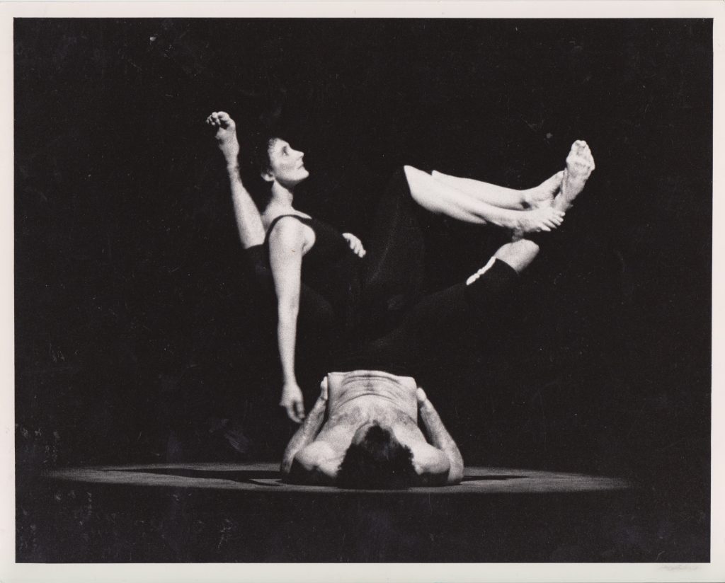A black and white photograph of two dancers in a floor lift.